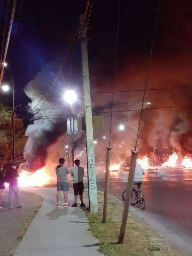 La imagen puede contener: una o varias personas, personas de pie, fuego, noche y exterior