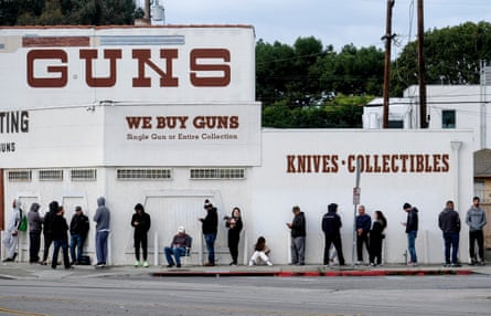 La gente espera en una fila para entrar a una tienda de armas en Culver City, California.