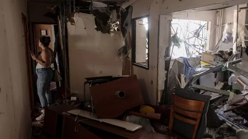 Una mujer entra al apartamento de sus padres despu&eacute;s de que fuera alcanzado por un cohete disparado desde Gaza, en Ashdod, Israel, el 17 de mayo de 2021.