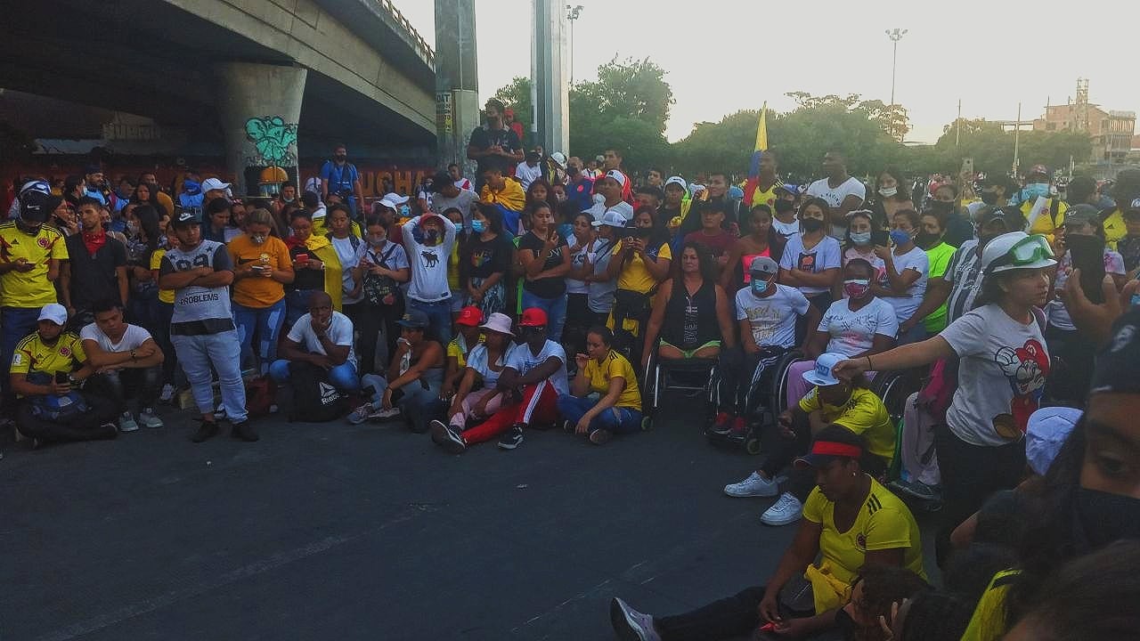 Puede ser una imagen de 2 personas, personas sentadas, personas de pie y carretera