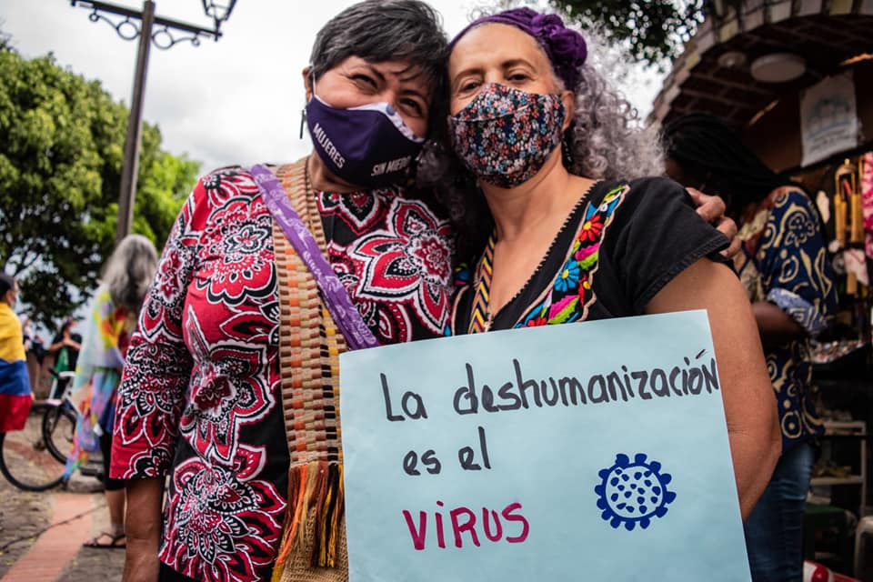 Puede ser una imagen de 1 persona, de pie, al aire libre y texto que dice "MUJERES La deshumanizaci&oacute;n es el VIRUS"