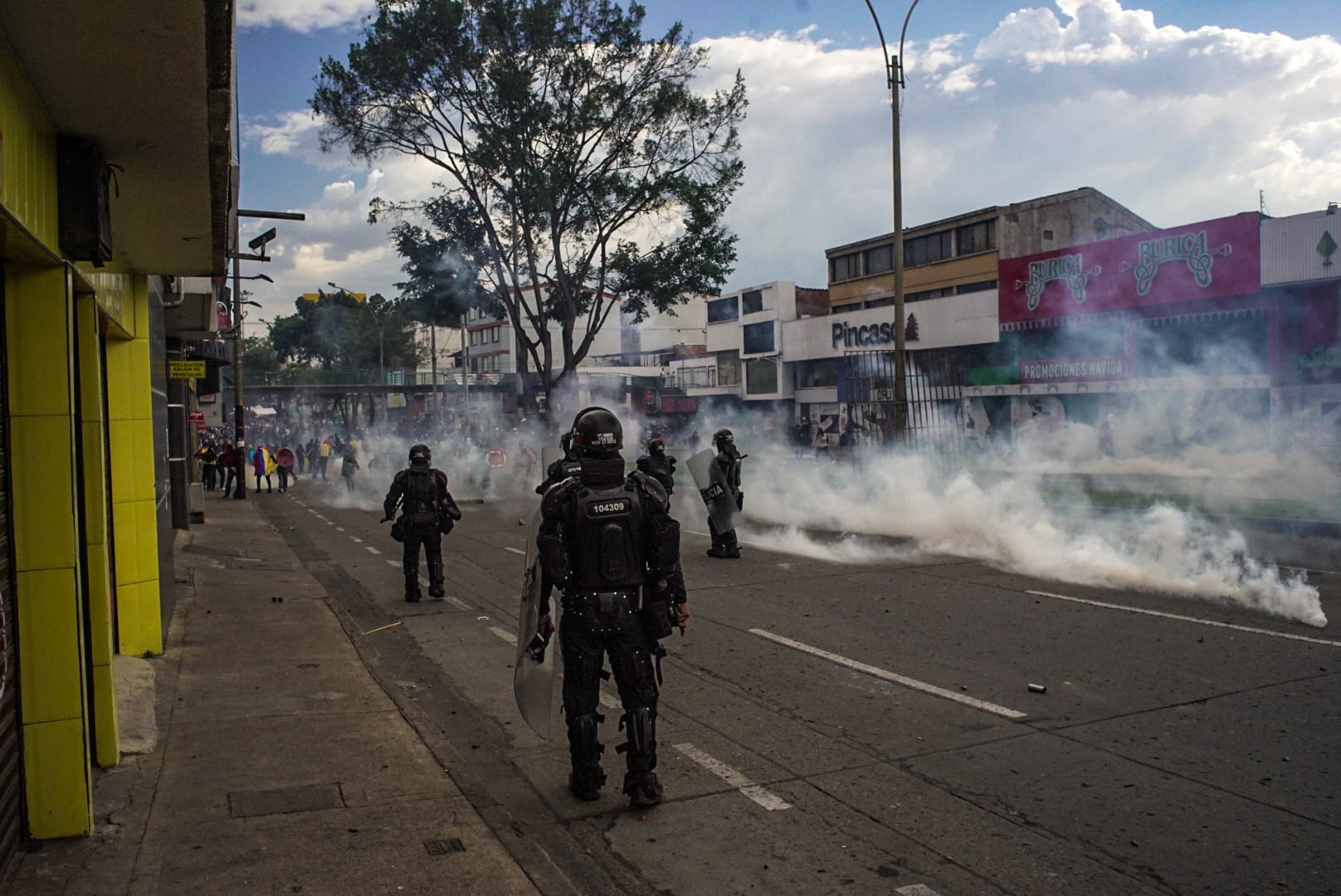 Puede ser una imagen de una o varias personas, personas de pie, moto y carretera