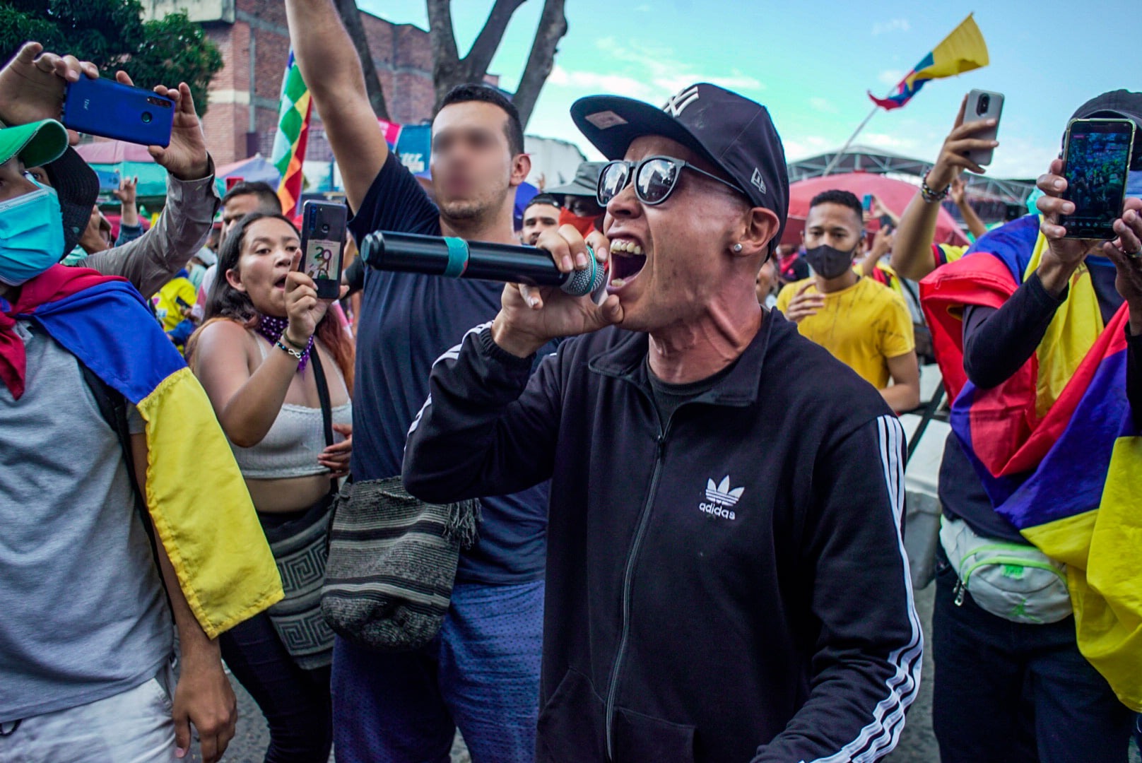 Puede ser una imagen de 4 personas, personas de pie, al aire libre, multitud y texto que dice "adidas"