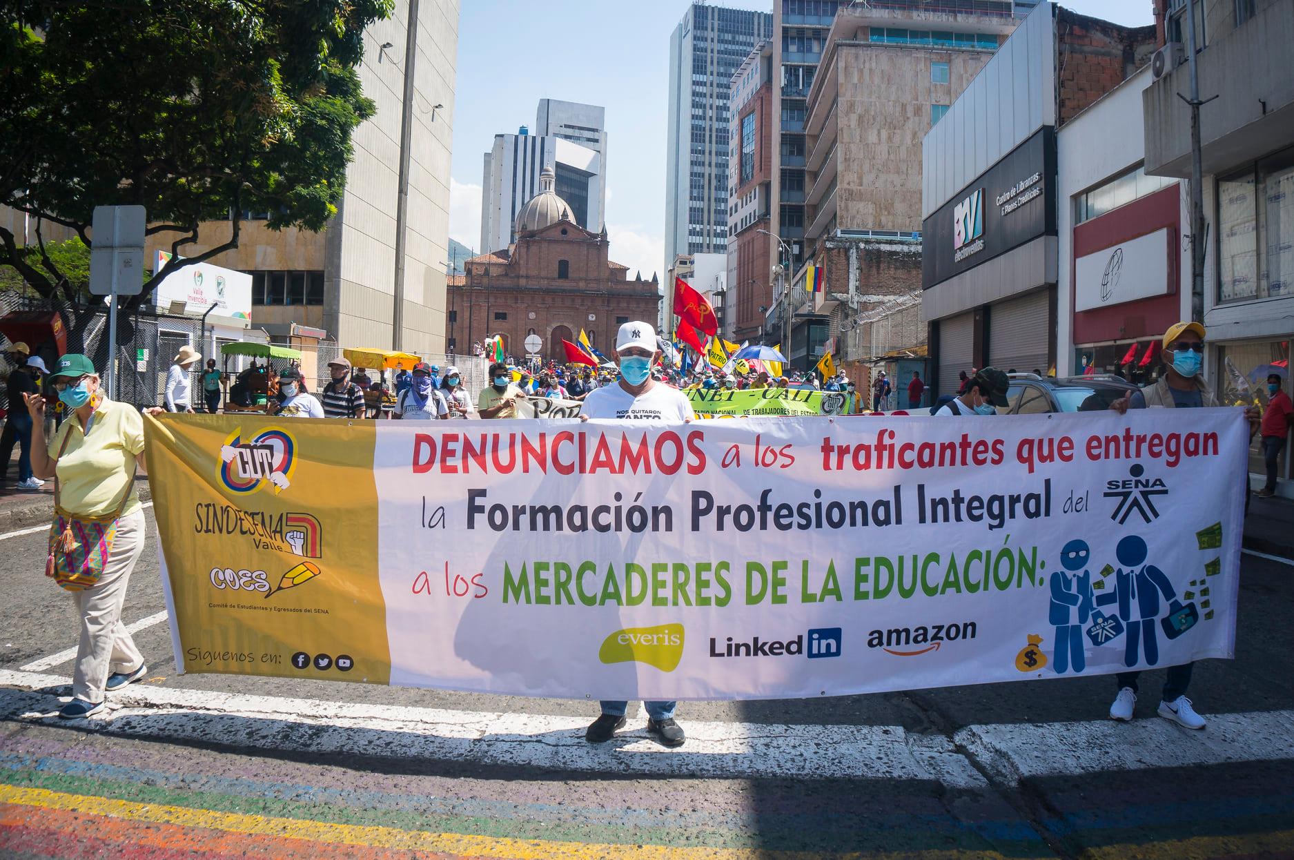 Puede ser una imagen de una o varias personas, carretera y texto que dice "T FansCaatces CIT SINDE COES TAGINA DENUNCIAMOS a los traficantes que entregan la Formaci&Atilde;&sup3;n Profesional Integral del a los MERCADERES DE LA EDUCACI&Atilde;N: everis Linkedi amazon"