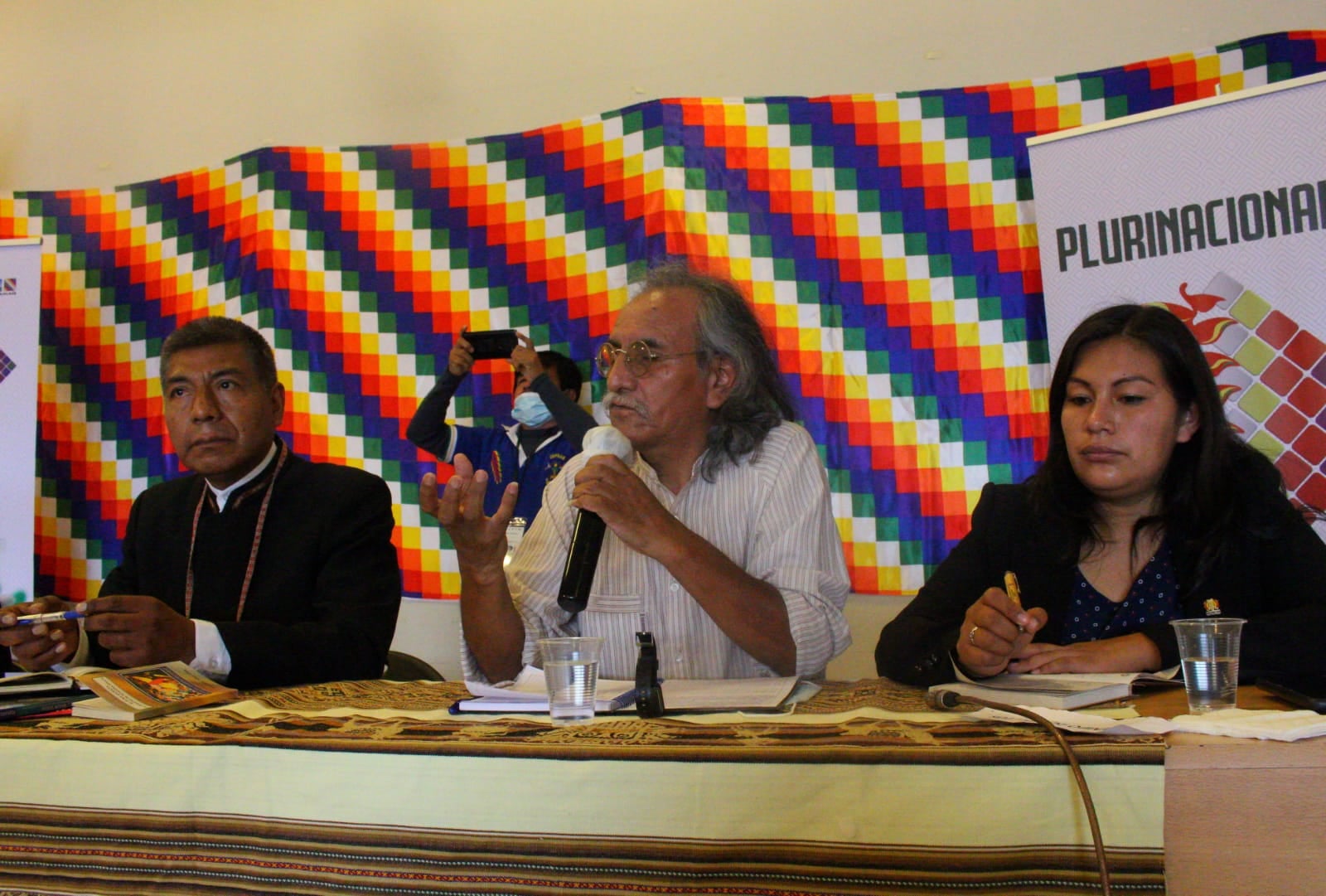 Puede ser una imagen de 3 personas, personas de pie, personas sentadas, interior y texto que dice "PLURINACIONA"